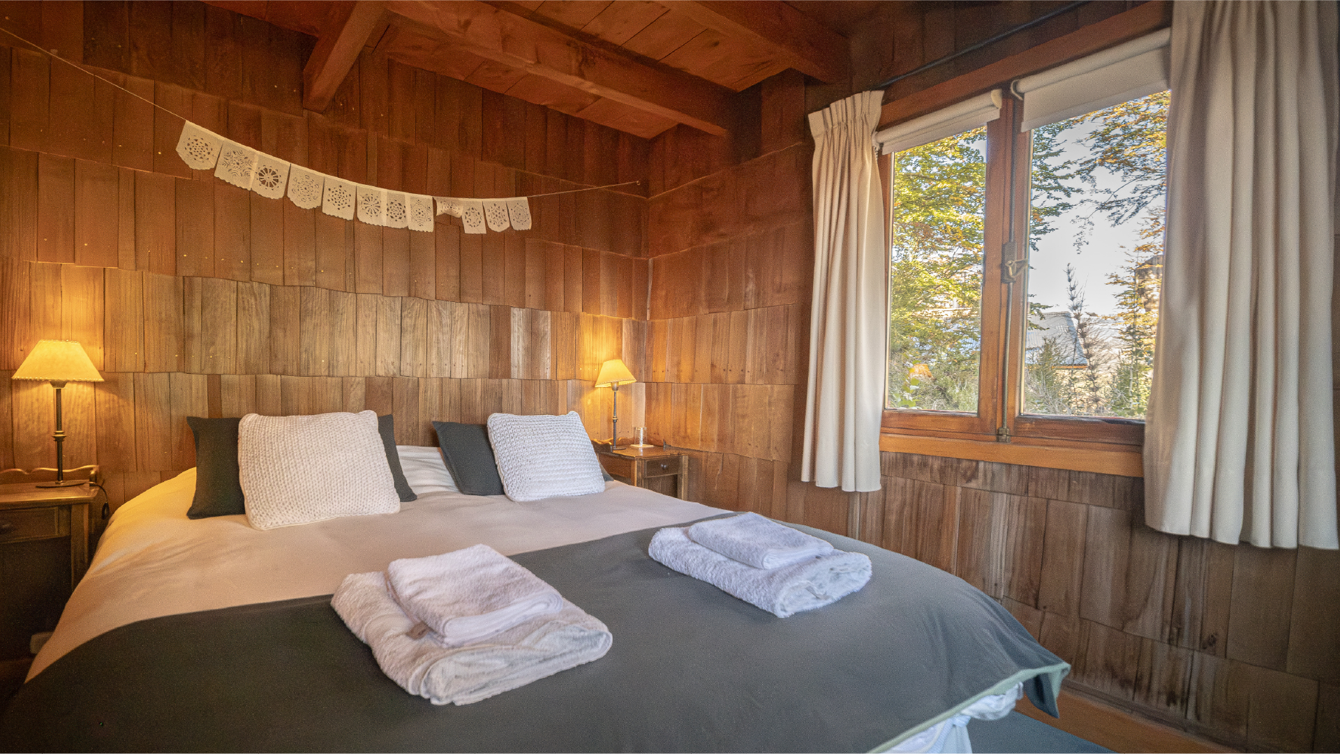 Habitación doble con cama matrimonial y terminaciones en madera